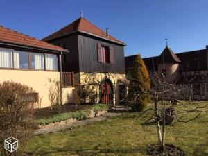 a house with a red door in a yard at La Gloriette Riquewihr in Riquewihr