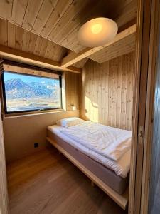 a bedroom with a bed in a room with a window at Storøya Lodge Lofoten in Vestvågøya