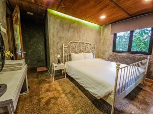 a bedroom with a white bed and a window at Templer Park Rainforest Retreat TPRR in Rawang +97 photos