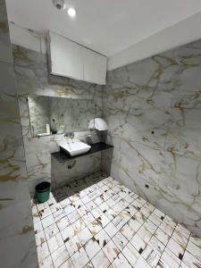 a bathroom with a sink and a marble wall at hotel shree palace in Ratlām +18 photos