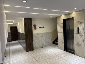 a lobby with marble walls and a elevator at hotel shree palace in Ratlām