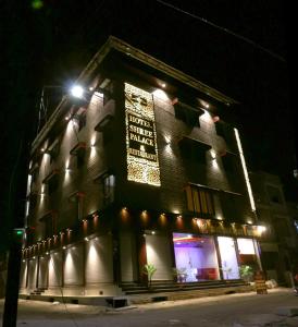 a building with a sign on the side of it at night at hotel shree palace in Ratlām