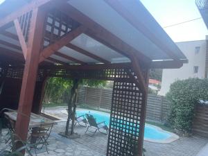 a wooden pergola over a swimming pool at Katy in Nice