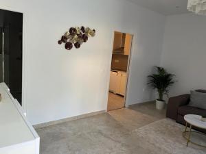 a living room with a couch and a clock on the wall at Katy in Nice +2 photos