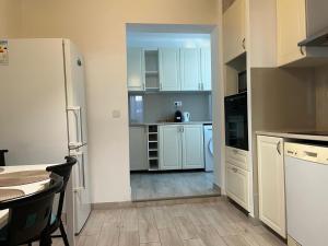 a kitchen with white cabinets and a white refrigerator at Katy in Nice