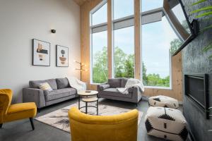 a living room with furniture and a large window at Käbane Horizon Boréal - Le Belvédère in Les Éboulements