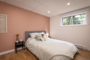 a bedroom with a large white bed with a window at Käbane Horizon Boréal - Le Belvédère in Les Éboulements +13 photos