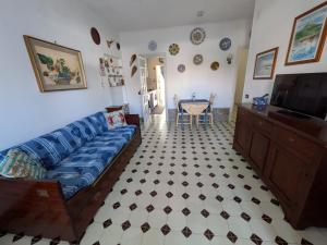 a living room with a blue couch and a table at Sunset House in Santa Marinella
