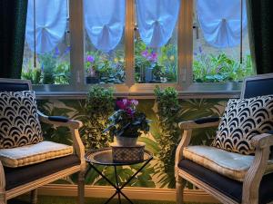 two chairs and a table in front of a window with flowers at Venetian dream apartment in Venice