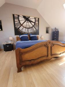 a bedroom with a large clock on the wall at La Maison Au 1894 bulles de bonheur et Spa in Avize