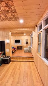 a room with a wooden floor and a living room at Dream River Resort in Batakūt
