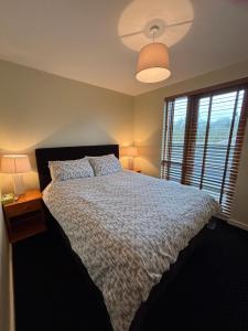 a bedroom with a large bed and a window at Courthouse View Penthouse 1 in Clifden