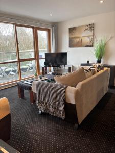 a living room with a couch and a television at Courthouse View Penthouse 1 in Clifden
