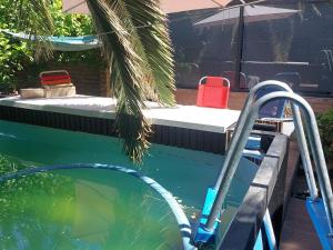 a swimming pool with a red chair in the water at Loft Salta in Bahía Blanca