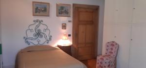 a bedroom with a bed and a chair and a lamp at Dimora Da Castello Lago Maggiore in Gravellona Toce