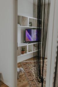 a television sitting on a white shelf in a room at BnB MAVIE & Whirlpool in Ingolstadt
