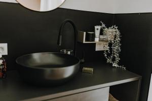 a bathroom with a sink and a black counter at BnB MAVIE & Whirlpool in Ingolstadt +34 photos