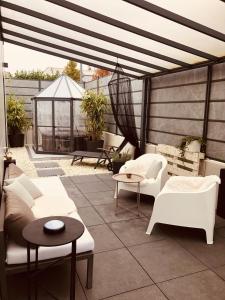 a patio with white couches and tables and a gazebo at BnB MAVIE & Whirlpool in Ingolstadt