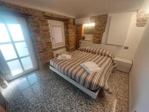 a bedroom with a bed and a large window at Affittacamere il Gallo Panoramico - Alpine Trekking Stay in Donato