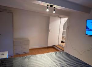 a bedroom with a bed and a tv on the wall at Rooms4Rent in Bottmingen