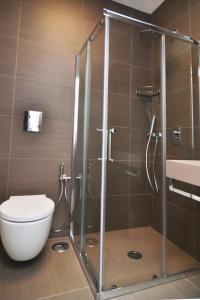 a bathroom with a shower with a toilet and a sink at Bed In Centro in Naples