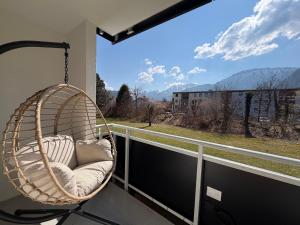 a hanging chair on a balcony with a view at Ferienwohnung Bergzeit in Pfronten