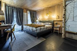 ein Schlafzimmer mit einem Bett, einem Tisch und einem Schreibtisch in der Unterkunft Hotel Letterario Locanda Collomb in La Thuile