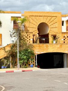 a building with an arched doorway and a parking garage at Oualidia surflodge in Oualidia