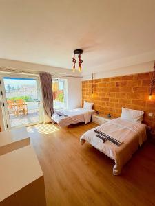 a bedroom with two beds and a brick wall at Oualidia surflodge in Oualidia