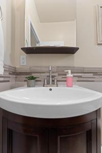 a white sink in a bathroom with a mirror at Marvelous Midtown Stay with a Modern Twist in Sacramento +23 photos