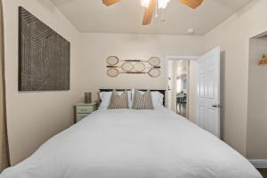 a bedroom with a white bed and a chandelier at Marvelous Midtown Stay with a Modern Twist in Sacramento