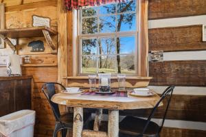 a table with chairs and a window in a cabin at Creekside Hideout in Cosby +21 photos