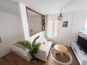 a living room with a couch and a tv at Le Japandi Maison confortable et calme à Libourne in Libourne