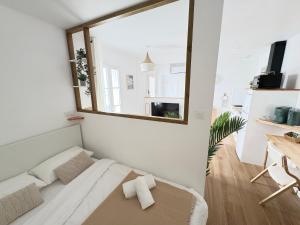a small room with a bed and a mirror at Le Japandi Maison confortable et calme à Libourne in Libourne