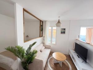 a living room with a couch and a tv at Le Japandi Maison confortable et calme à Libourne in Libourne