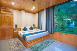 a bedroom with a bed and a large window at Khwaab Stays in Shoja