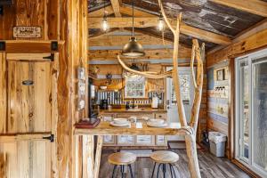 a log cabin kitchen with a table and stools at Creekside Treehouse in Cosby