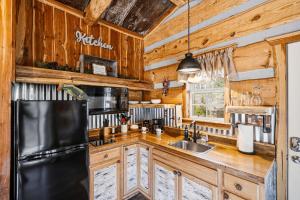 a kitchen with wooden cabinets and a black refrigerator at Creekside Treehouse in Cosby +24 photos