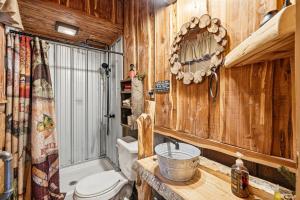 a bathroom with a toilet and a sink at Creekside Treehouse in Cosby