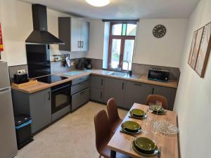 a kitchen with a table and chairs in a kitchen at Le Fond du Village in Solre-Saint-Géry