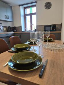 a table with plates and wine glasses on it at Le Fond du Village in Solre-Saint-Géry +9 photos