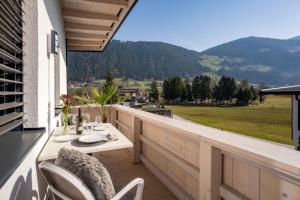 a patio with a table and chairs on a balcony at Ferienwohnungen Roko in Schlitters