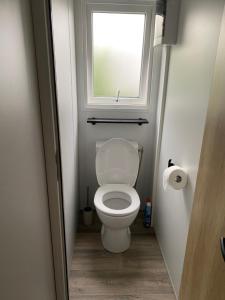 a small bathroom with a toilet with a window at Bungalow 6 personnes in Équihen-Plage +22 photos