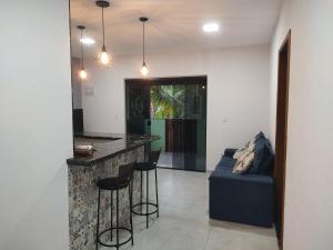 a living room with a bar and a blue couch at Eloá Mar's Corner in Angra dos Reis