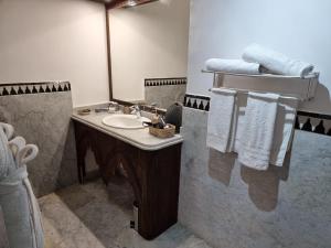a bathroom with a sink and a mirror and towels at Riad Batchisarai in Fez +109 photos