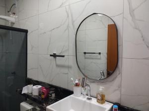 a bathroom with a sink and a mirror at Eloá Mar's Corner in Angra dos Reis