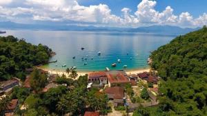 a beach with a group of people in the water at Eloá Mar's Corner in Angra dos Reis