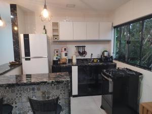 a kitchen with black appliances and a white refrigerator at Eloá Mar's Corner in Angra dos Reis +11 photos