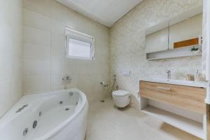 a bathroom with a tub and a toilet and a sink at Villa Oaza in Bar +20 photos