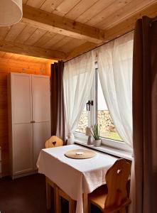 a dining room with a table and a window at Apartamenty & Domek Gawędówka in Krościenko